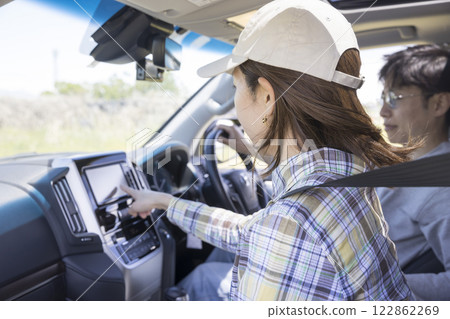 A woman setting up the car navigation system in the passenger seat 122862269