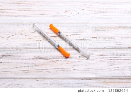 Top view of insulin syringe prepared for injection at wooden background. Diabetes concept with copy space Top view of insulin syringe prepared for injection at wooden background. Diabetes concept with copy space 122862654