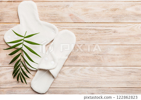 lean feminine sanitary napkin with green leaf. Absence of menstruation in woman. Minimal concept of female menopause. Copy space top view 122862823