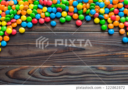 Mixed collection of colorful candy, on colored background. Flat lay, top view. frame of colorful chocolate coated candy Mixed collection of colorful candy, on colored background. Flat lay, top view. frame of colorful chocolate coated candy 122862872