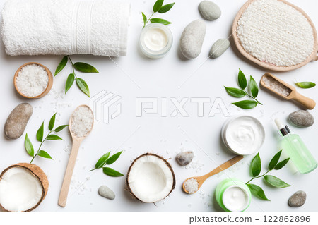 Coconut with jars of coconut oil and cosmetic cream on colored background. Top view. Free space for your text. Natural spa coconut cosmetics and organic treatment concept Coconut Spa composition 122862896