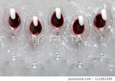 Many glasses of red wine at wine tasting. Concept of red wine on colored background. Top view, flat lay design 122862899