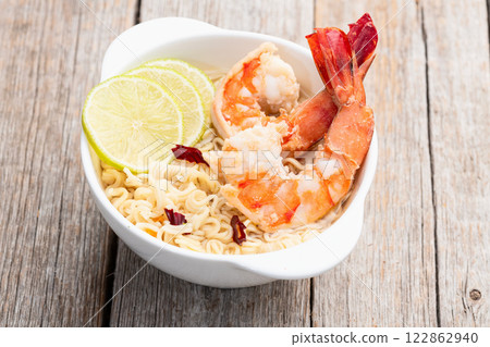 Tom yum soup with shrimps instant noodles and lime photography . Asian food . Top view Tom yum soup with shrimps instant noodles and lime photography . Asian food . Top view 122862940