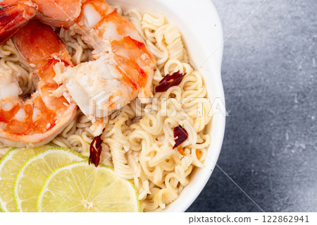 Tom yum soup with shrimps instant noodles and lime photography . Asian food . Top view 122862941