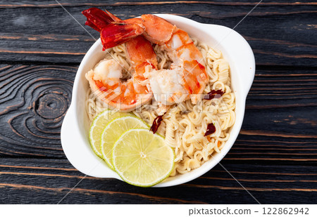 Tom yum soup with shrimps instant noodles and lime photography . Asian food . Top view 122862942