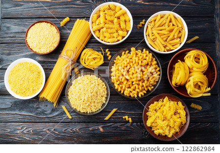 Assorted Uncooked Pasta in Bowls on Wooden Table 122862984