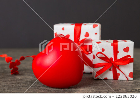 gift box with red bow and red heart on colored background. Perspective view. Flat lay gift box with red bow and red heart on colored background. Perspective view. Flat lay 122863026