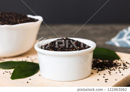 quinoa seeds in bowl on colored background. Healthy kinwa in small bowl. Healthy superfood quinoa seeds in bowl on colored background. Healthy kinwa in small bowl. Healthy superfood 122863062