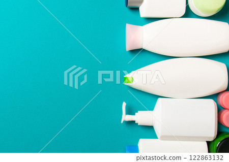 Top view of cosmetics bottles on colored background. Skin care concept with space for your design Top view of cosmetics bottles on colored background. Skin care concept with space for your design 122863132