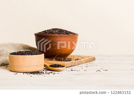 quinoa seeds in bowl and spoon on colored background. Healthy kinwa in small bowl. Healthy superfood quinoa seeds in bowl and spoon on colored background. Healthy kinwa in small bowl. Healthy superfood 122863152