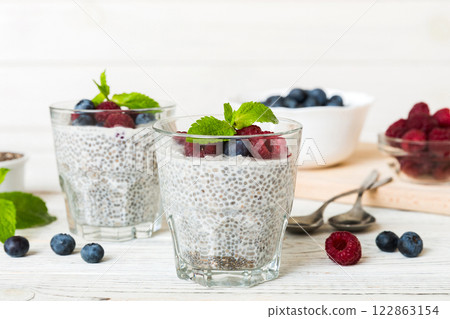 Healthy breakfast or morning with chia seeds vanilla pudding raspberry and blueberry berries on table background, vegetarian food, diet and health concept. Chia pudding with raspberry and blueberry Healthy breakfast or morning with chia seeds vanilla pudding raspberry and blueberry berries on table background, vegetarian food, diet and health concept. Chia pudding with raspberry and blueberry 122863154