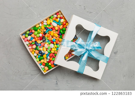 Box with sweet chocolate candies on color background, Various candy sweets. Valentines day gift box. Top view flat lay with copy space Box with sweet chocolate candies on color background, Various candy sweets. Valentines day gift box. Top view flat lay with copy space 122863183