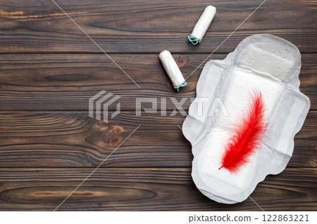 women pads and tampon - sanitary pads lies next to a tampon on an isolated background on a pink and violet background. Women's hygiene and menstrual period concept 122863221