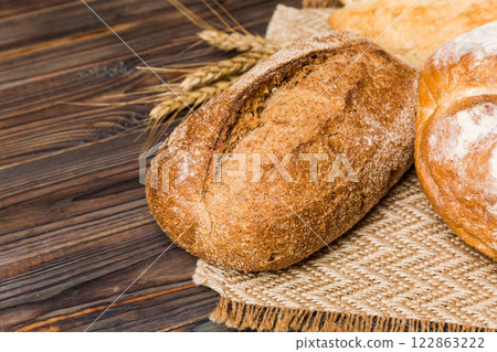 Homemade natural breads. Different kinds of fresh bread as background, perspective view with copy space Homemade natural breads. Different kinds of fresh bread as background, perspective view with copy space 122863222