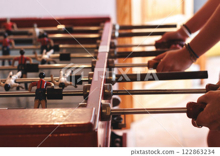 Exciting Foosball Game in Action with Players 122863234