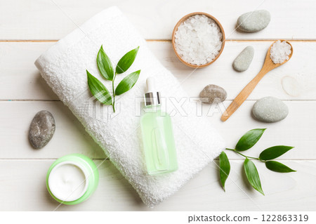 Coconut with jars of coconut oil and cosmetic cream on colored background. Top view. Free space for your text. Natural spa coconut cosmetics and organic treatment concept Coconut Spa composition 122863319