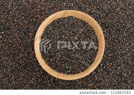 black quinoa in wooden bowl as a background. Top view. Flat lay 122863582