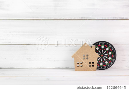 Wooden House with Dartboard on White Wooden Background Representing Real Estate Targeting 122864645