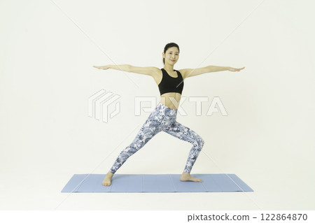 Young woman doing warrior pose yoga on white background 122864870
