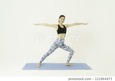 白色背景下做戰士瑜珈的年輕女子 白色背景下做戰士瑜珈的年輕女子 122864871