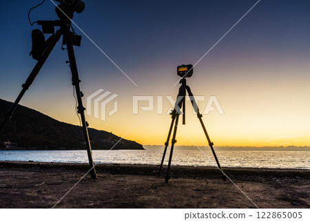 Camera taking picture film of sunset over sea surface Camera taking picture film of sunset over sea surface 122865005