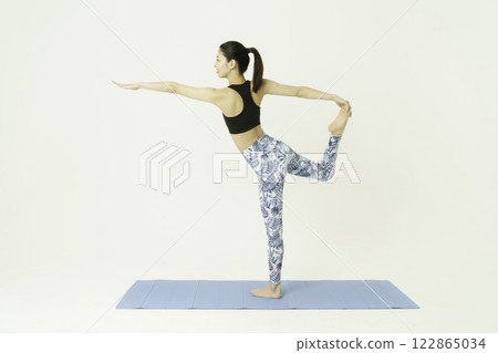 Young woman doing dancer pose on white background, yoga 122865034