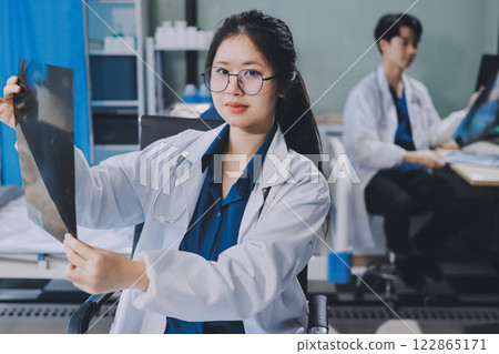 Positive doctor working on laptop in medical office, portrait. Positive doctor working on laptop in medical office, portrait. 122865171