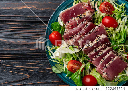 Salad with raw tuna , sesame and cherry tomatoes photography . Top view 122865224