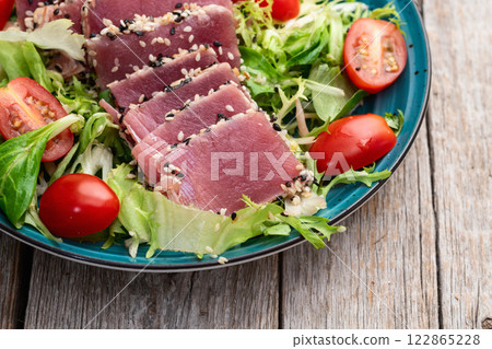 Salad with raw tuna , sesame and cherry tomatoes photography . Top view 122865228