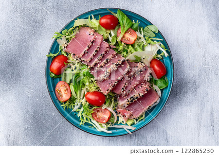 Salad with raw tuna , sesame and cherry tomatoes photography . Top view Salad with raw tuna , sesame and cherry tomatoes photography . Top view 122865230