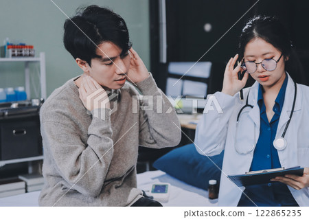 Female physician reads medical history while visiting her patient 122865235