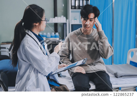 Female physician reads medical history while visiting her patient 122865237
