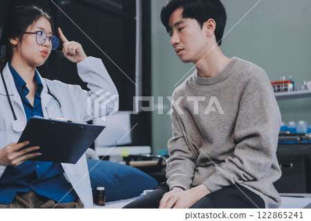 Female physician reads medical history while visiting her patient 122865241