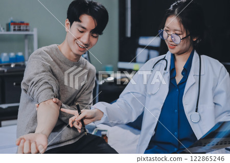 Female physician reads medical history while visiting her patient Female physician reads medical history while visiting her patient 122865246