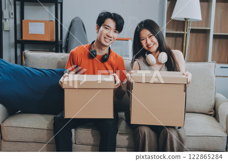 Smiling couple unpacking boxes in new house 122865284