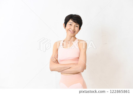 Middle-aged woman in gym wear posing with arms crossed Middle-aged woman in gym wear posing with arms crossed 122865861