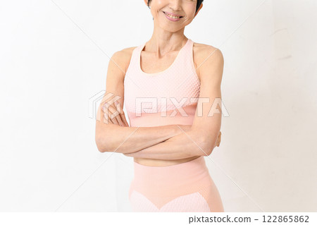 Middle-aged woman in gym wear posing with arms crossed Middle-aged woman in gym wear posing with arms crossed 122865862