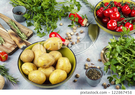 Raw potato and red tomatoes on a table 122867458