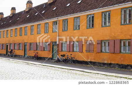 Beautiful view of old yellow houses in famous Nyboder district with a bikes. Beautiful view of old yellow houses in famous Nyboder district with a bikes. 122868365