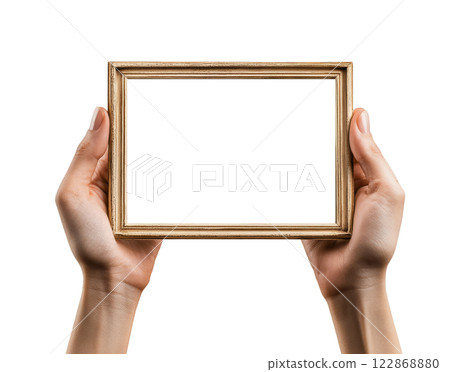 Two hands holding a blank, rectangular, gold picture frame are isolated on a transparent background. 122868880