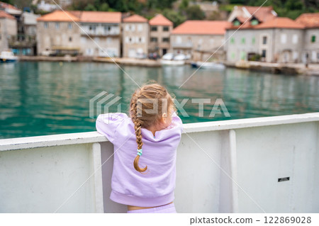 Little girl traveling with family by ferry. Crossing from one bank to another of Kotor bay in Montenegro 122869028