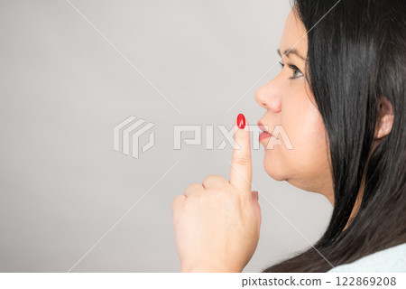 Woman asking for silence with finger on lips Woman asking for silence with finger on lips 122869208