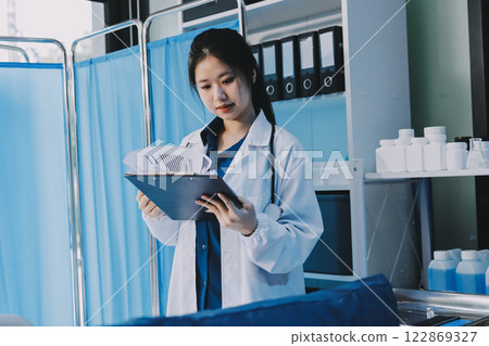 Positive doctor working on laptop in medical office, portrait. 122869327
