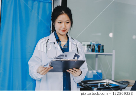 Positive doctor working on laptop in medical office, portrait. 122869328