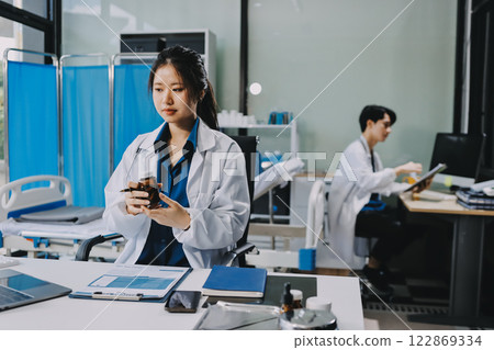 Positive doctor working on laptop in medical office, portrait. Positive doctor working on laptop in medical office, portrait. 122869334