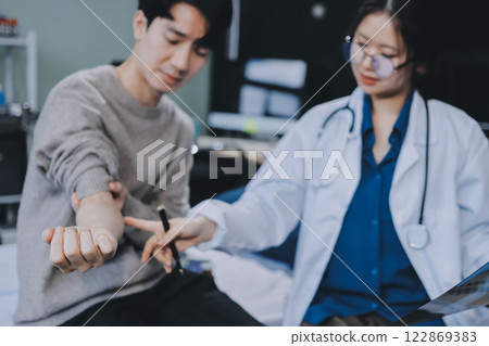 Female physician reads medical history while visiting her patient Female physician reads medical history while visiting her patient 122869383