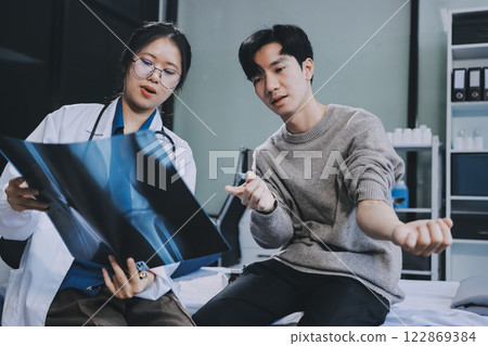 Female physician reads medical history while visiting her patient 122869384
