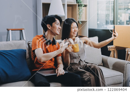 Smiling couple unpacking boxes in new house 122869404