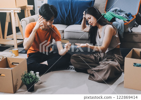 Young frustrated millennial couple sitting on couch at home, using computer and credit card. Buyers try to pay online have shortage of money on bank account. Extra expenses and big spender concept Young frustrated millennial couple sitting on couch at home, using computer and credit card. Buyers try to pay online have shortage of money on bank account. Extra expenses and big spender concept 122869414