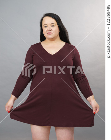 Woman showing size of brown top tunic Woman showing size of brown top tunic 122869498